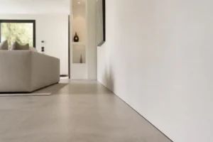 Transition sol mur sans plinthe avec joint d'ombre entre mur blanc et carrelage grand format