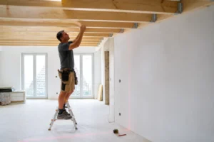 Pose de solives en bois massif pour un solivage de plafond dans une maison en rénovation