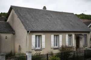 Maison individuelle française avec toiture ancienne en plaques fibrociment gris, vue extérieure de face
